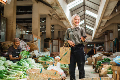 Portrait of woman holding vegetables for sale at market