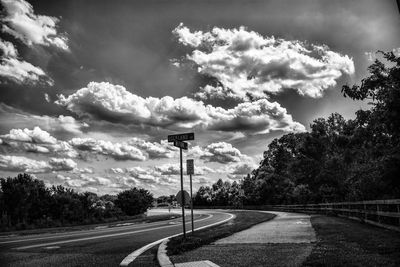 Road by trees against sky