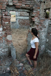 Woman standing in front of stone wall