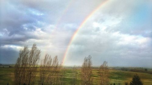 Rainbow over landscape against sky