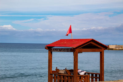 Built structure by sea against sky
