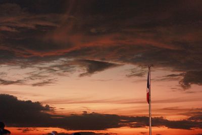 Low angle view of silhouette flag against sky during sunset