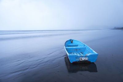 View of blue boat on empty beach