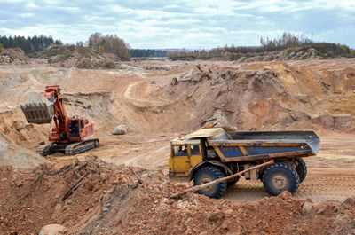 Tractor in construction site against sky