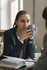 Mid section of a man holding coffee cup