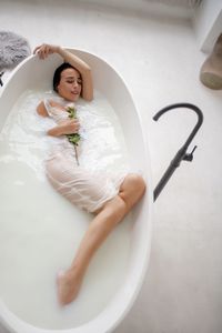 Beautiful woman sitting in bathtub