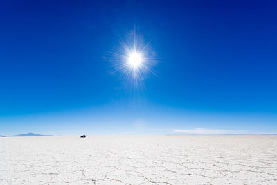 Salt flat against clear blue sky during sunny day
