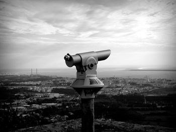 Close-up of telescope against cloudy sky