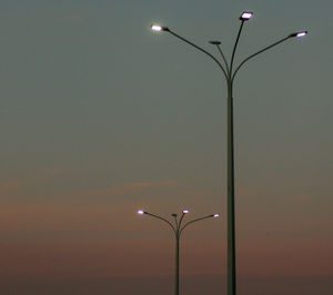 Low angle view of illuminated street light against sky at sunset