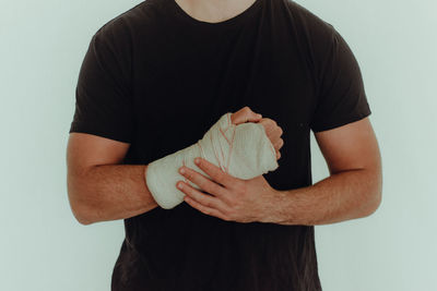Midsection of man holding ice cream against white background