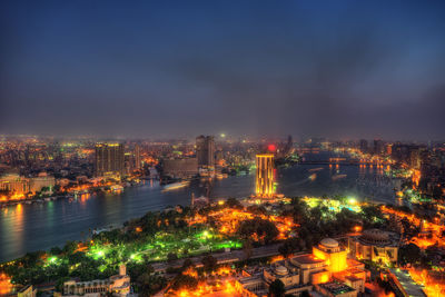 High angle view of illuminated buildings against sky at night