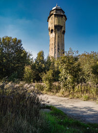 Water tower on field against sky