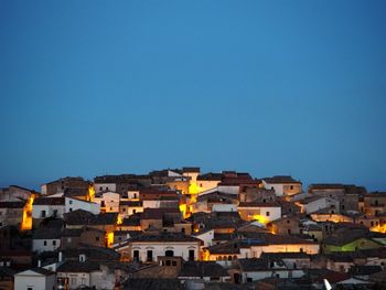 Buildings in city against clear blue sky