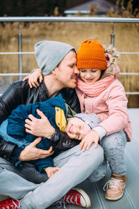 Father and two children walk in nature in autumn, spend time together, have fun.
