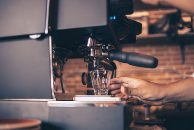 Midsection of person having coffee at cafe