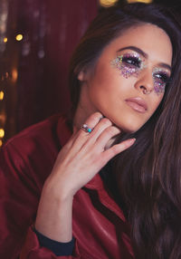 Thoughtful young woman with glitter eye make-up