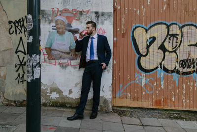 Full length of man standing against wall