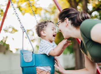 Side view of mother carrying daughter at playground