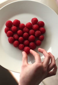 Close-up of cropped hand holding strawberries