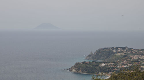 Scenic view of sea and mountains against sky