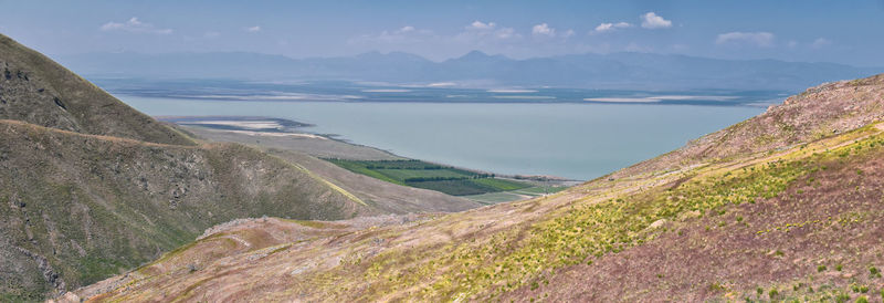 Scenic view of sea and mountains against sky