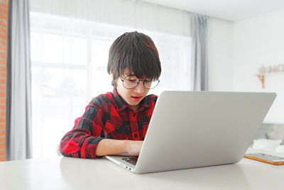 Boy using laptop at home