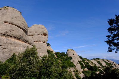 Low angle view of rocks against blue sky