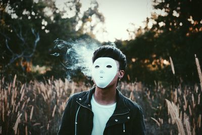 Smoke behind man in mask standing on field