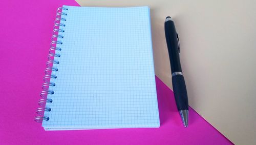 Pen and note pad on table