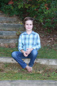 Portrait of a smiling young man sitting on grass