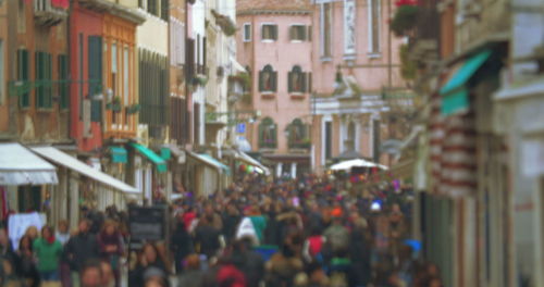 People on street against buildings in city