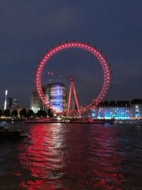 Illuminated ferris wheel at night