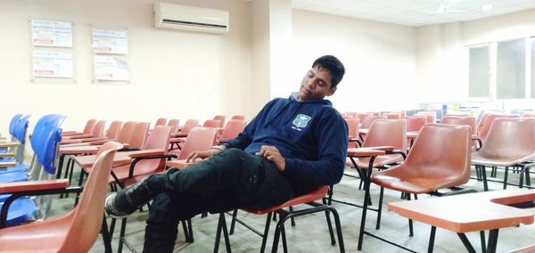 Portrait of young man sitting on table