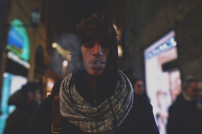 Close-up of man exhaling smoke at night