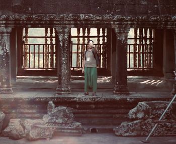 Rear view of woman standing against window in building