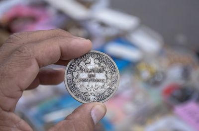 Cropped hand of person holding coin