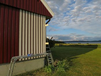 View of field against cloudy sky