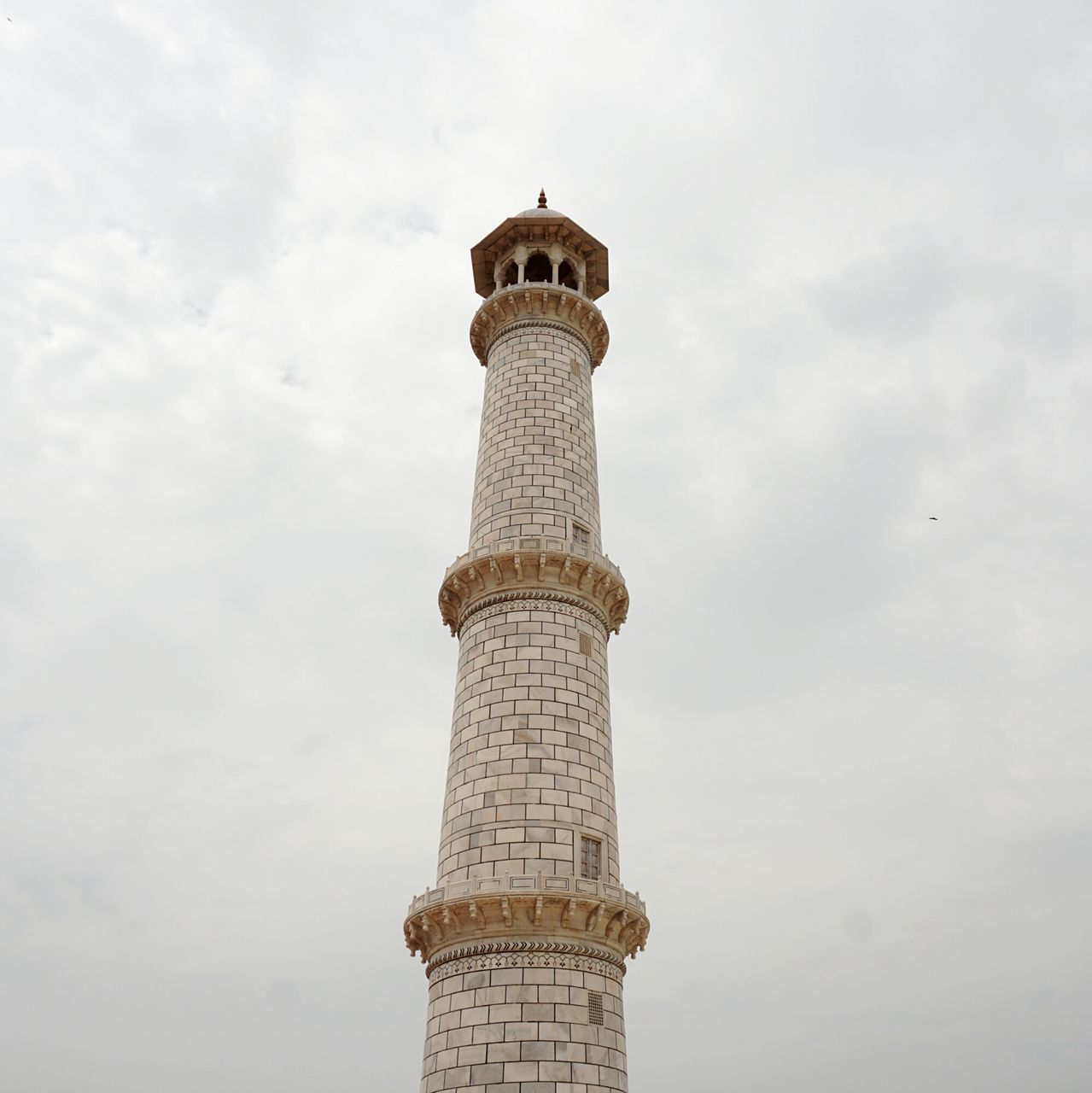 LOW ANGLE VIEW OF TOWER IN CITY AGAINST CLOUDY SKY