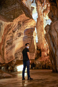 Rear view of man standing in cave