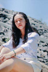 Portrait of young woman sitting staircase