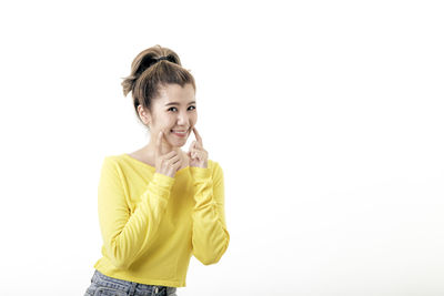 Portrait of smiling young woman against white background