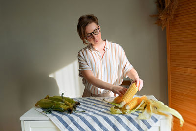 Young woman holding food on table at home