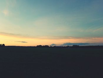 Scenic view of silhouette field against sky during sunset