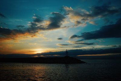 Scenic view of sea against dramatic sky during sunset