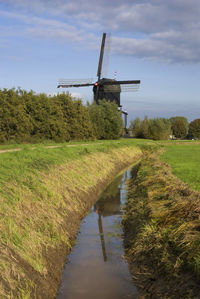 Traditional windmill on field against sky