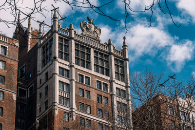 Low angle view of buildings against cloudy sky
