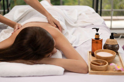 Rear view of woman sitting on bed at home