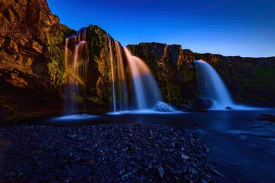 Scenic view of waterfall against rocks