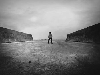 Rear view of woman standing against wall