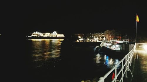 Boats moored at harbor against sky at night